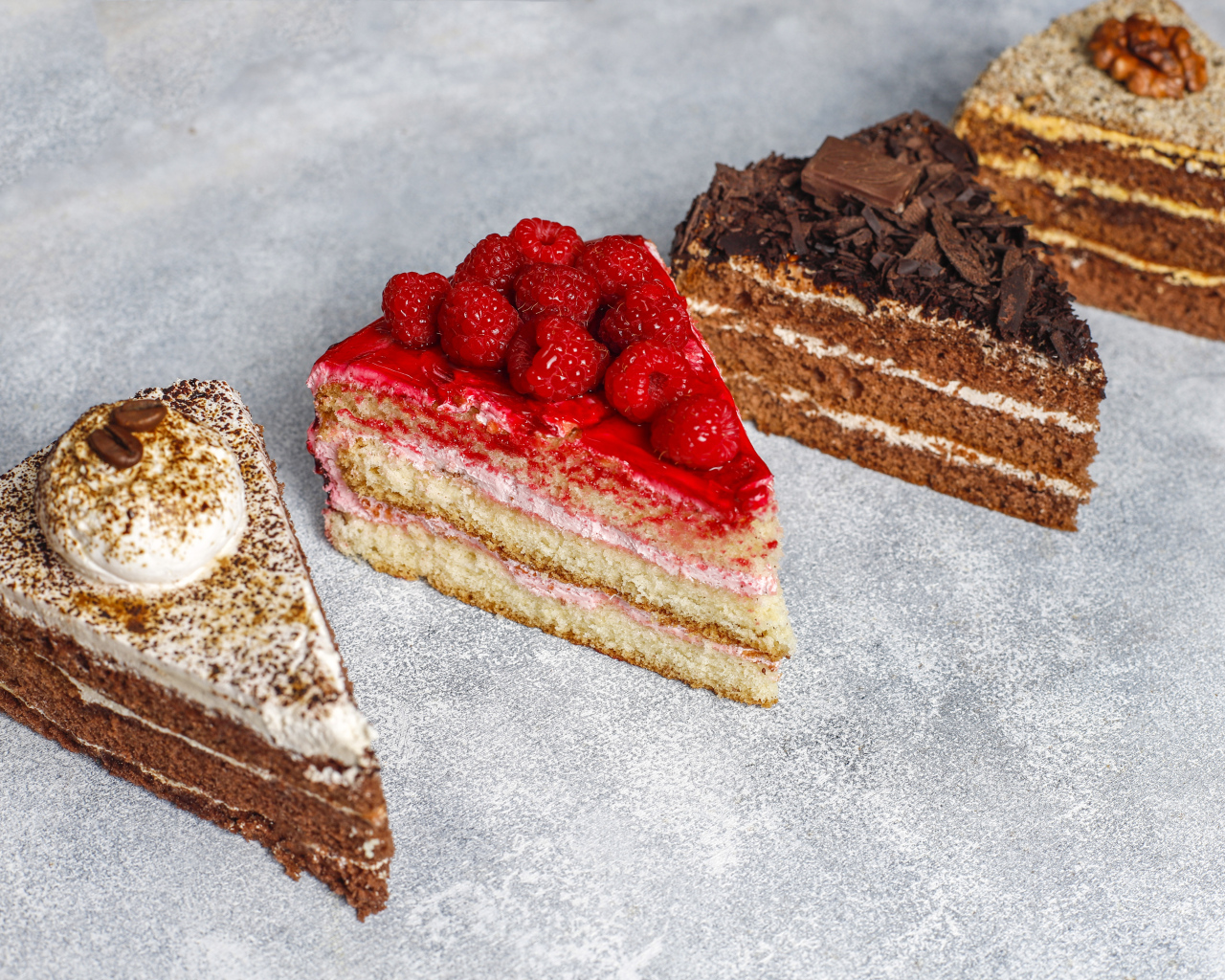 Четыре разных вкусных куска торта на столе