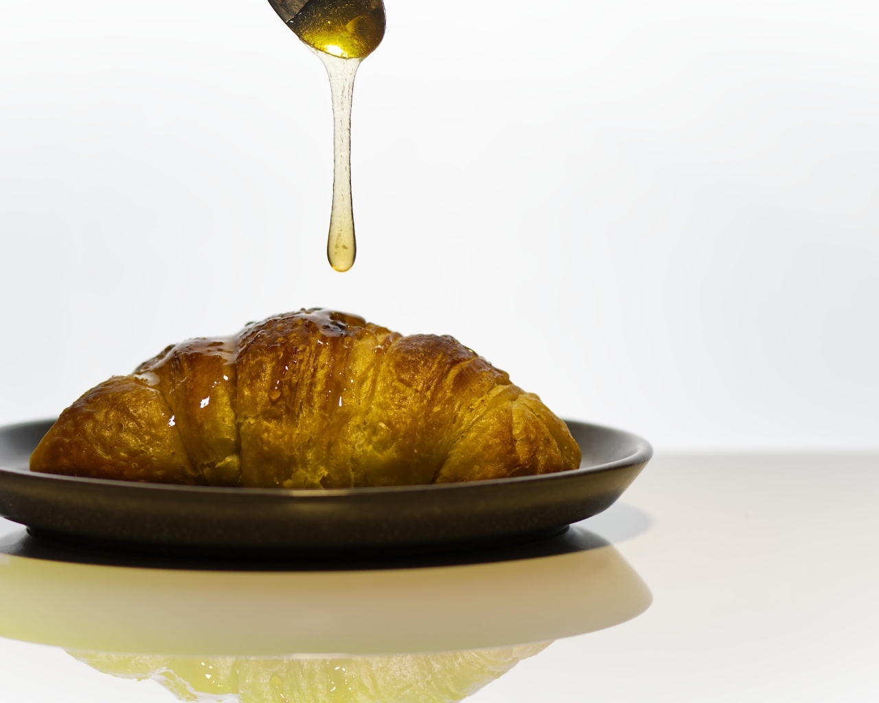 Свежий круассан с медом на завтрак