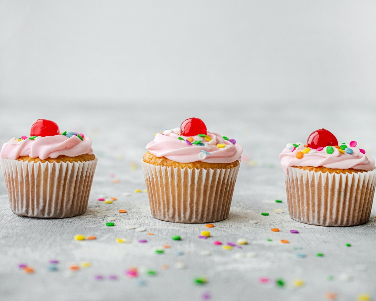 Маффины с кремом и вишней на столе