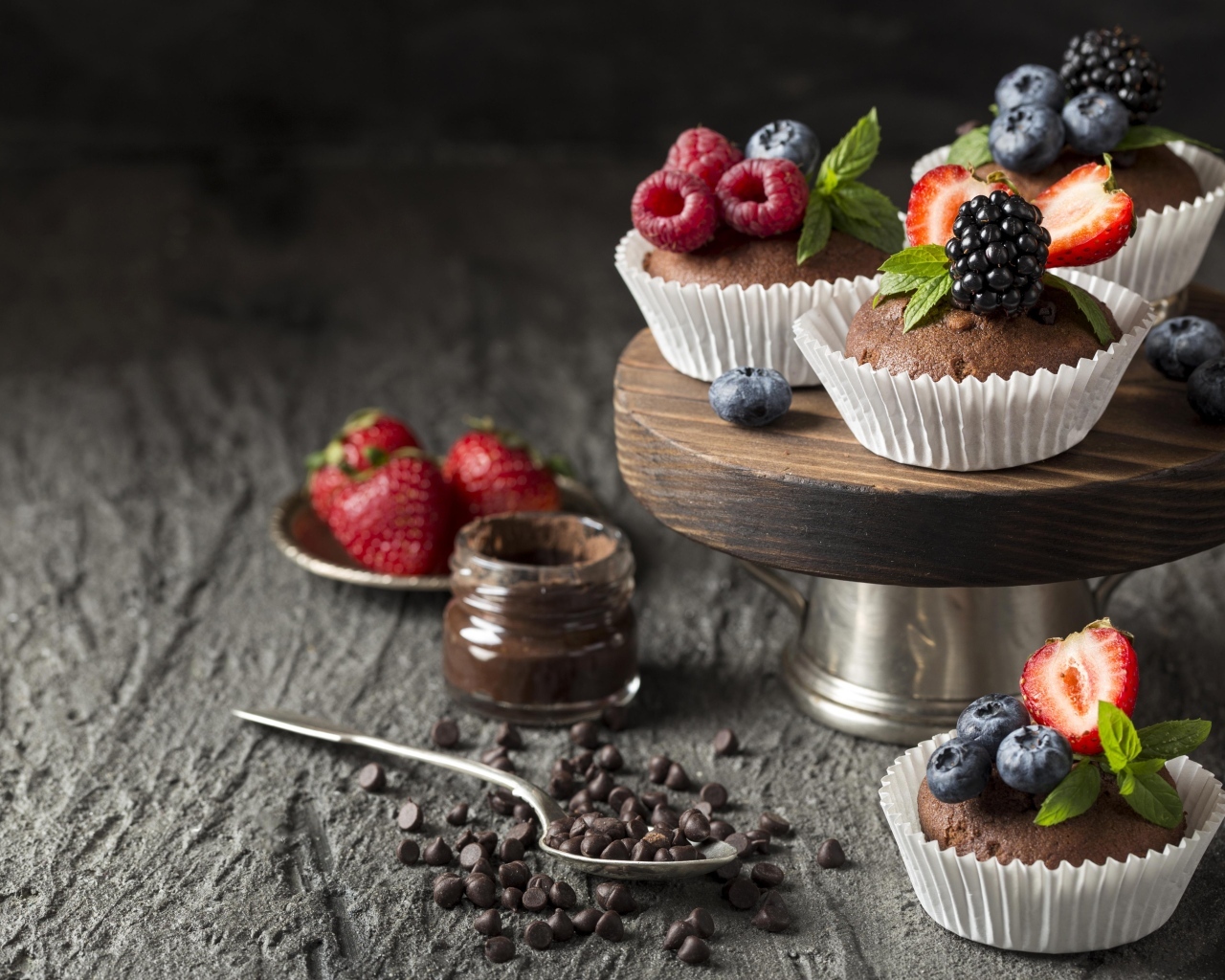 Кексы со свежими ягодами на столе с шоколадом