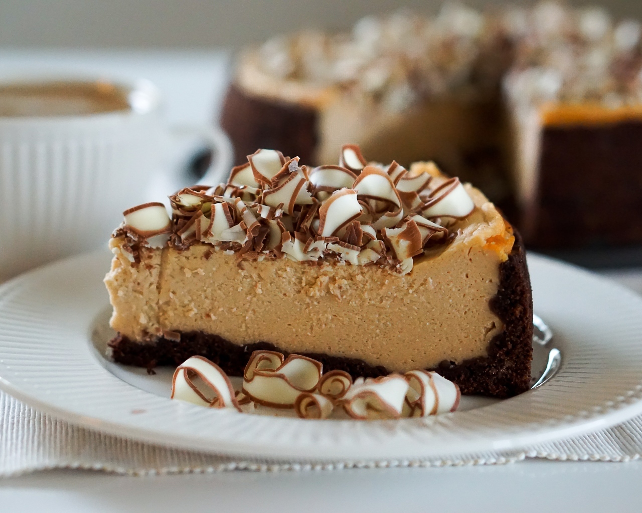 Кусок торта с шоколадной стружкой на белой тарелке