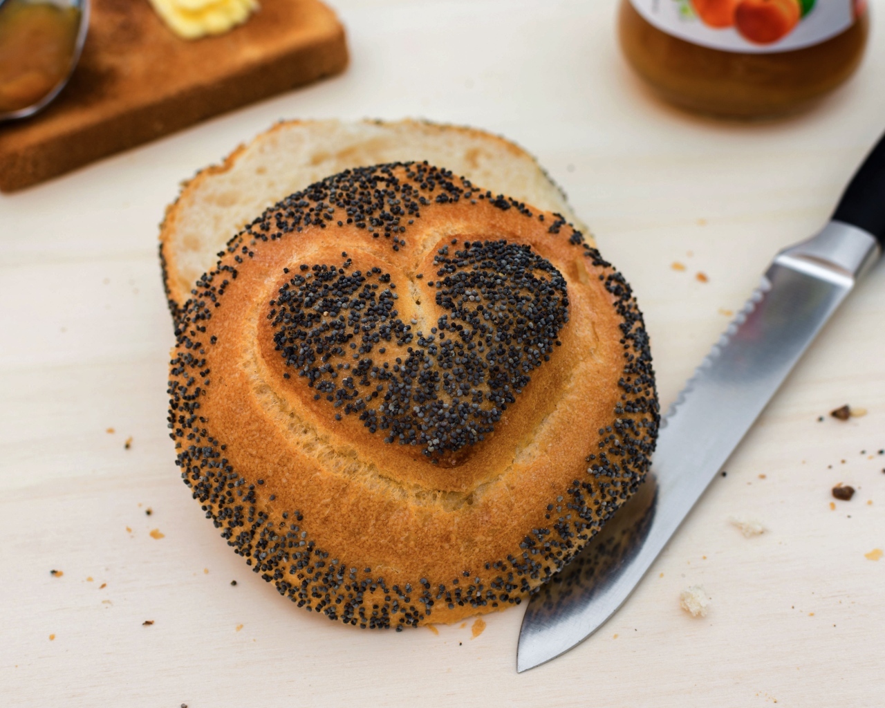 Булочка с маком с нарисованным сердцем на столе