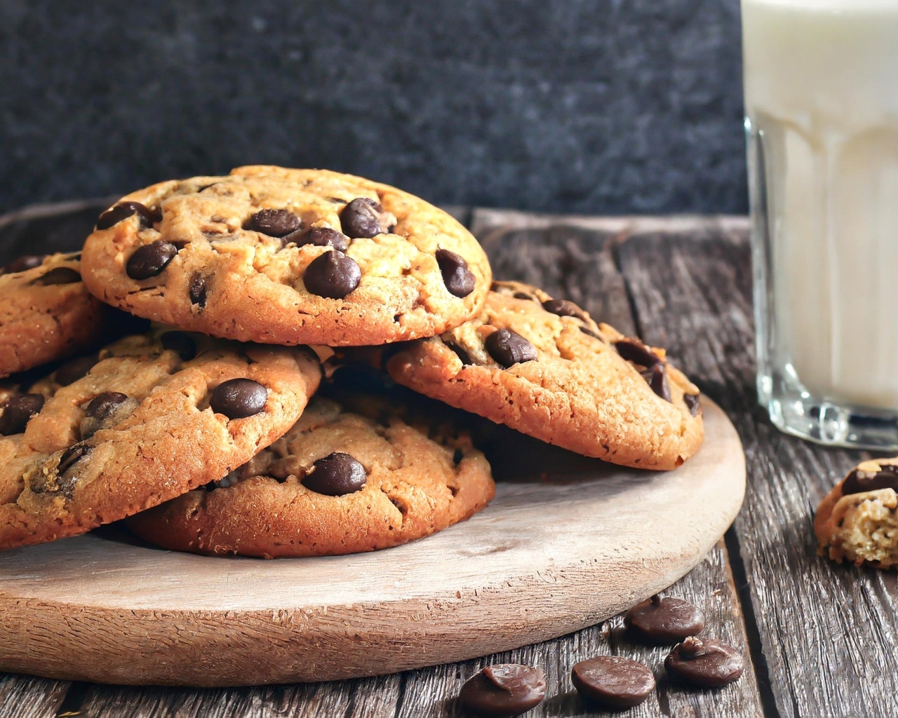 Круглое печенье с шоколадом на столе со стаканом молока