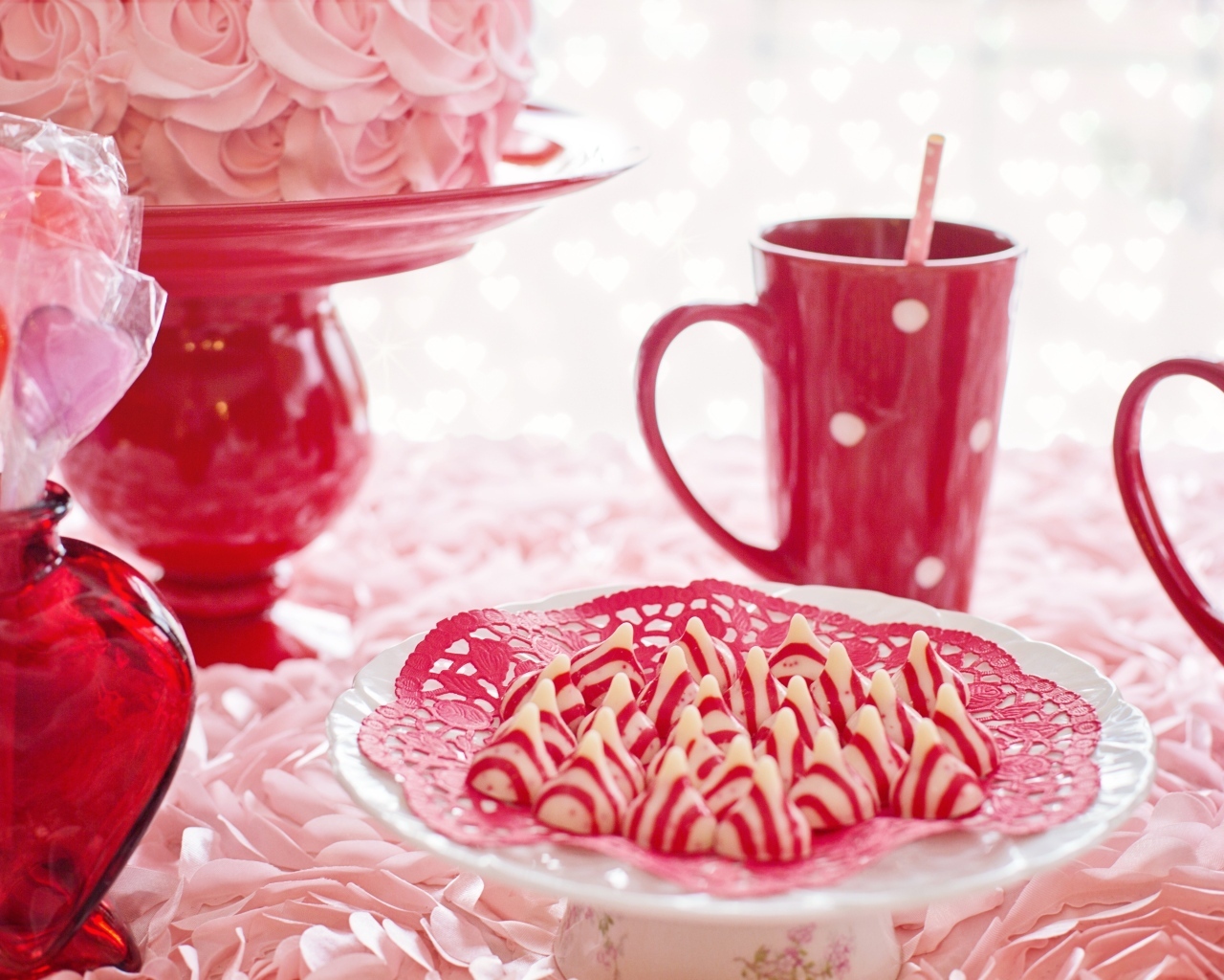 Сладкие розовые конфеты на столе с чаем и тортом