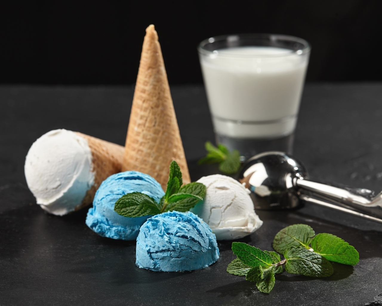 Вафельный рожок с шариками мороженого, мятой и молоком на столе