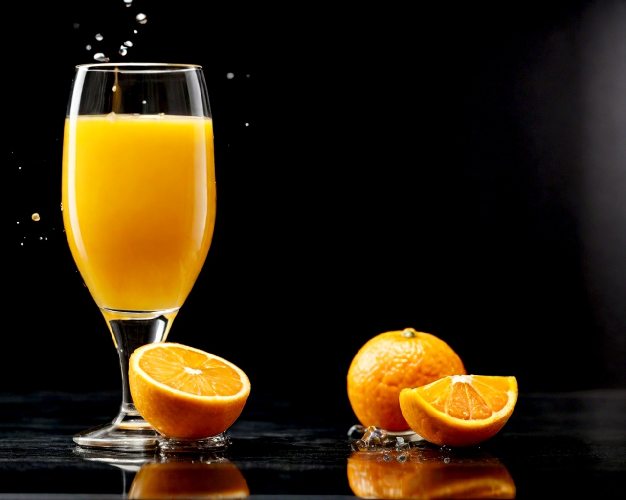 Стакан апельсинового сока с фруктами на столе