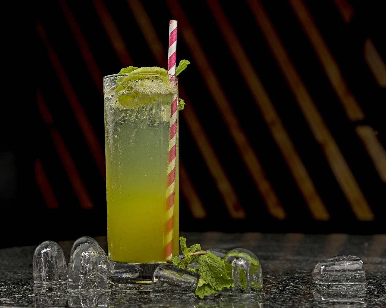 Зеленый коктейль мохито в высоком стакане со льдом