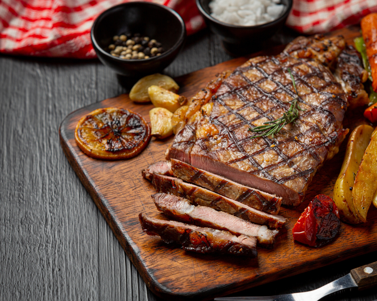 Кусок мясо барбекю на доске с овощами