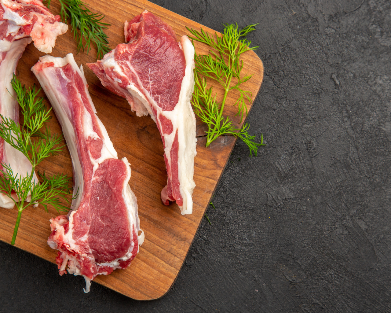 Свиные ребра на разделочной доске с укропом