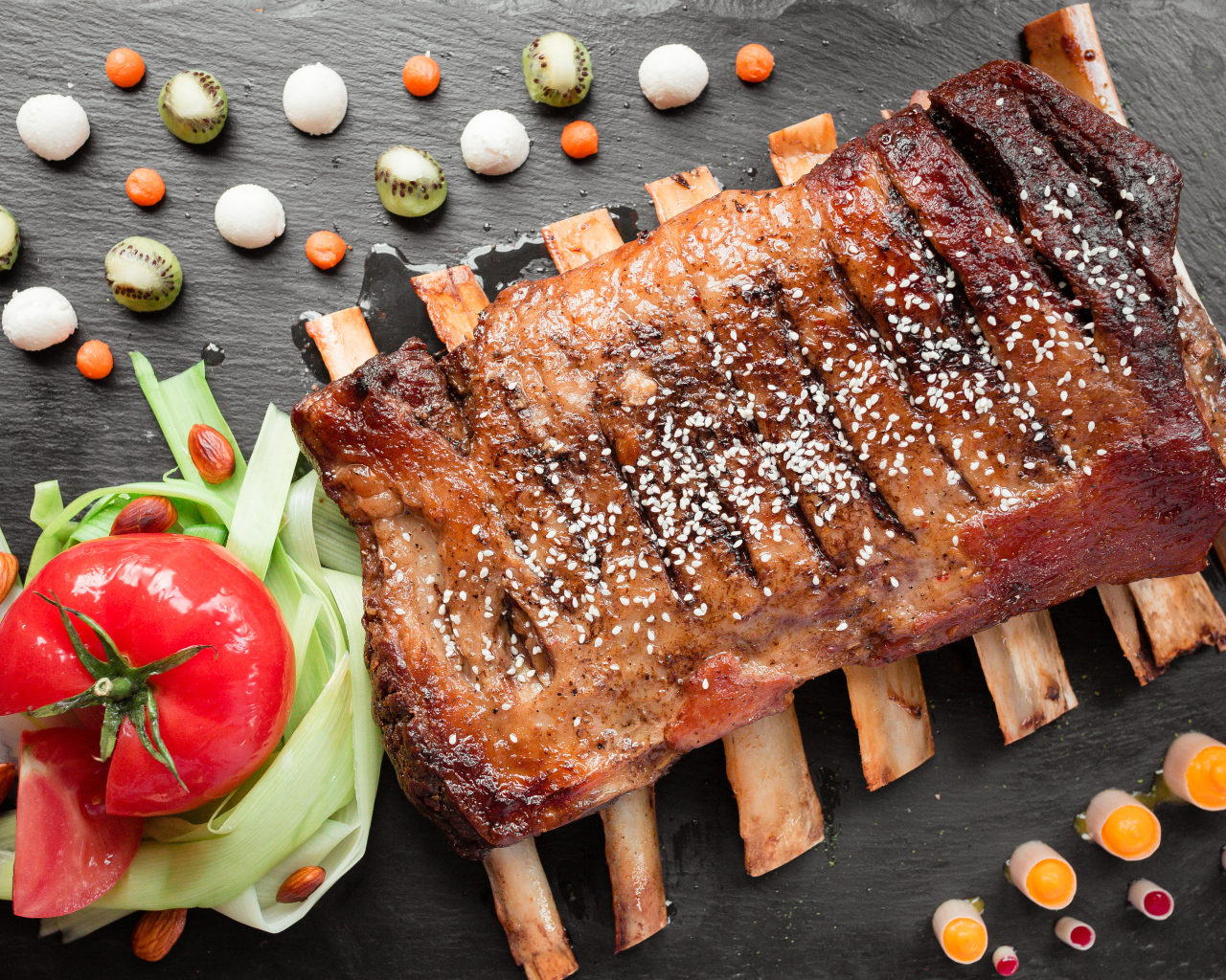 Свиные ребра на столе с овощами