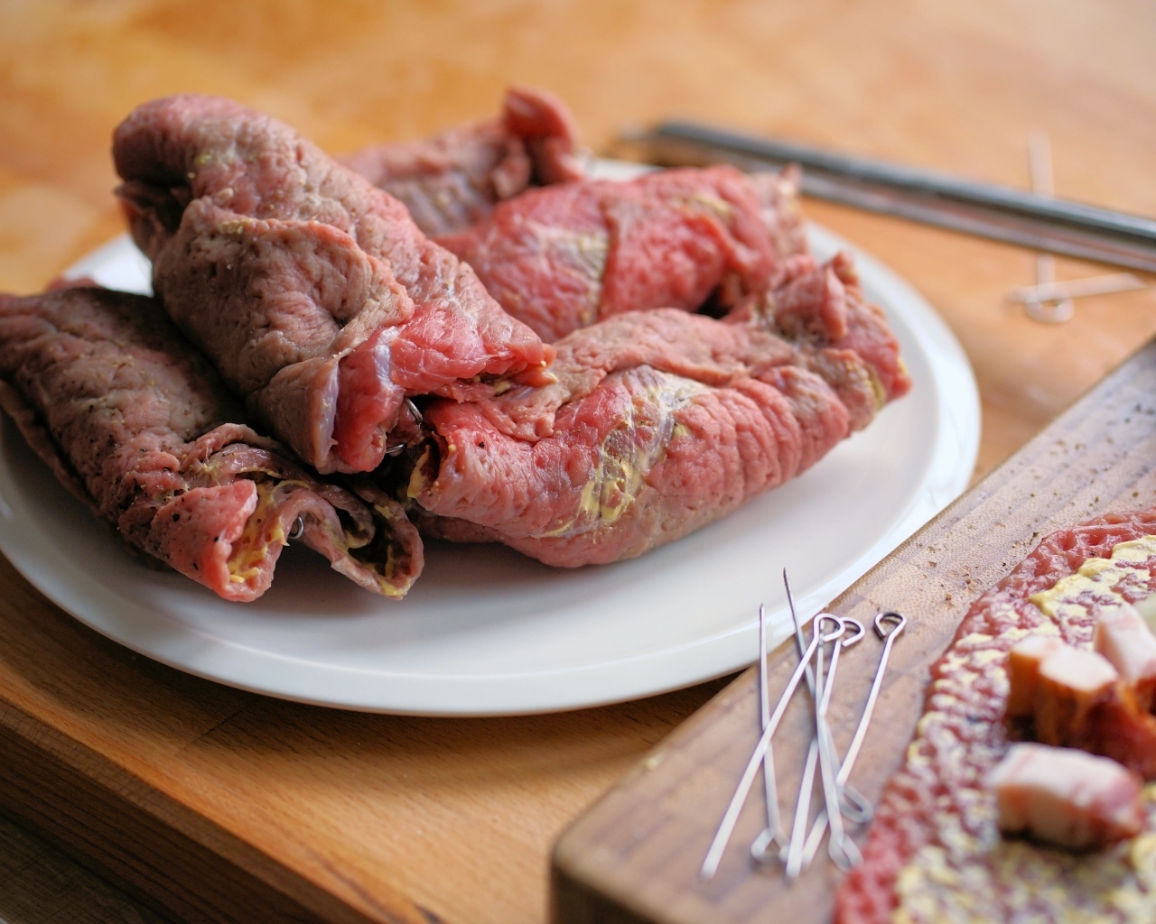 Рулетики из свинины на большой белой тарелке