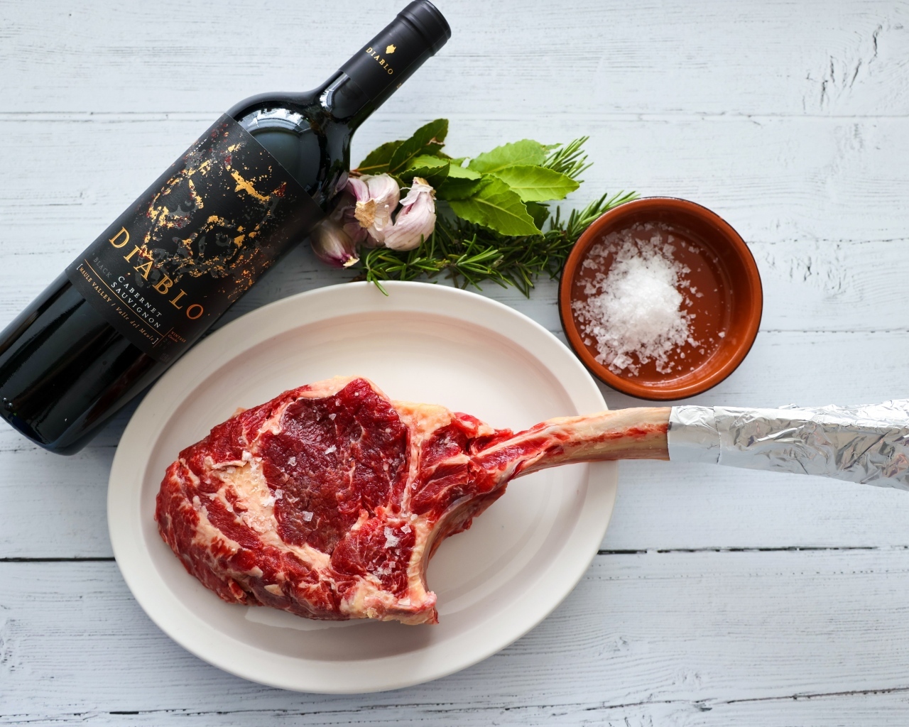 Стейк на кости с бутылкой вина