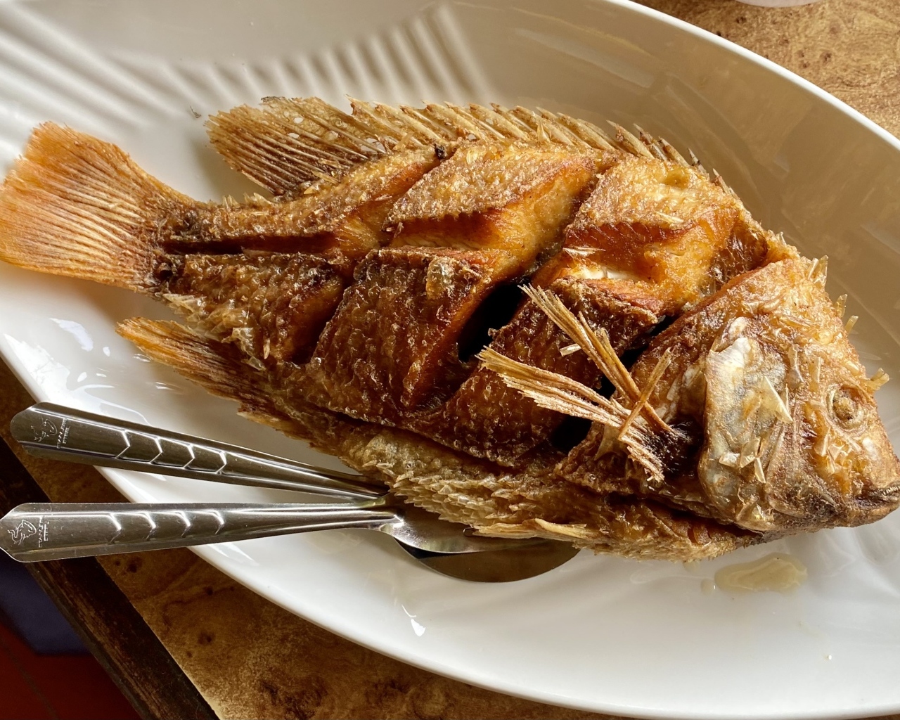 Запеченный карп на белой тарелке