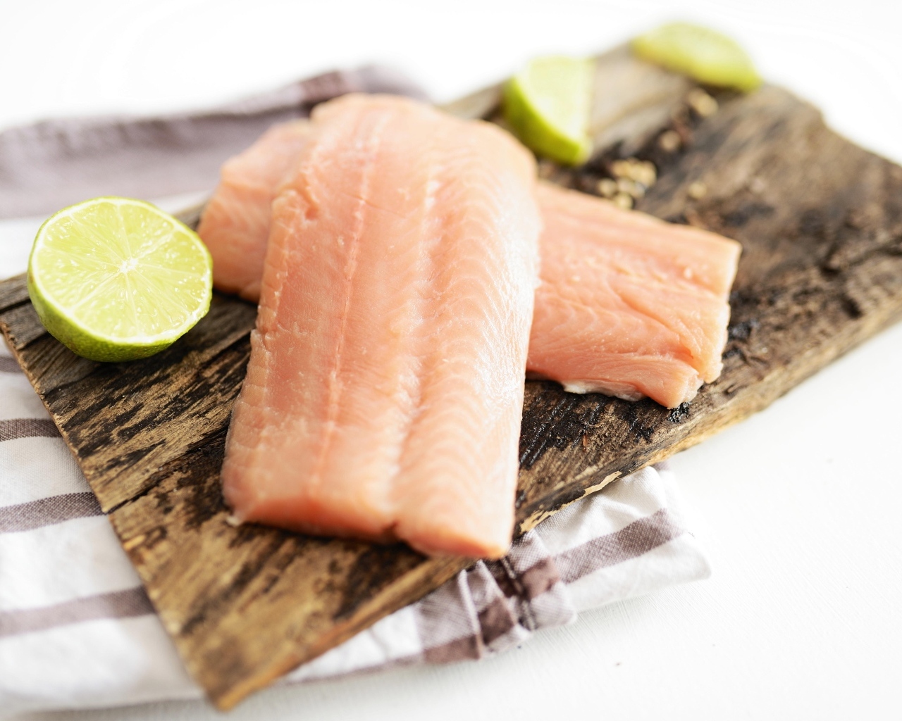 Кусочки рыбы на столе с лаймом