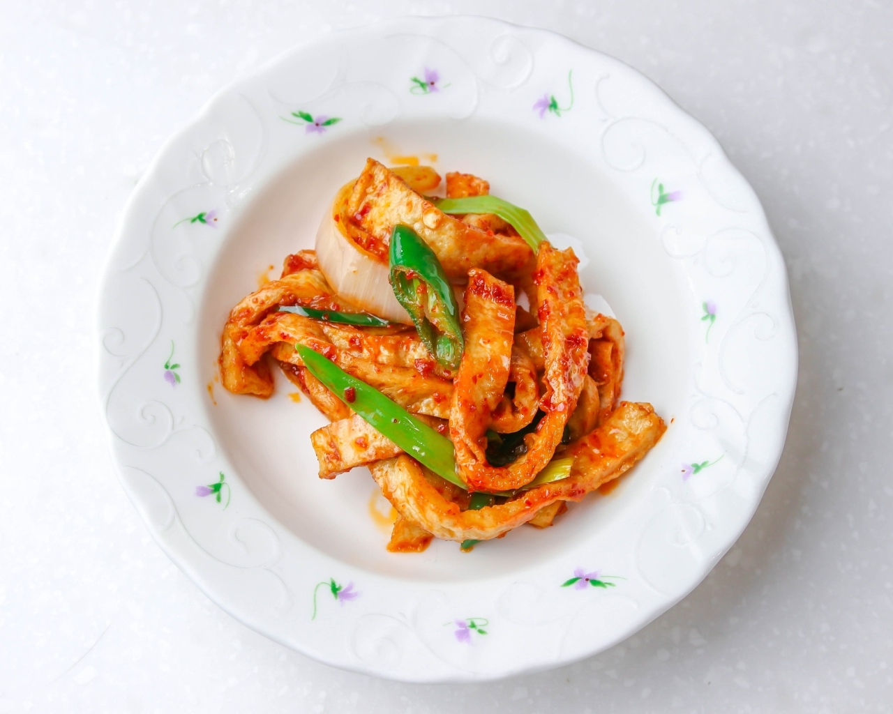 Острая рыба кусочками на тарелке