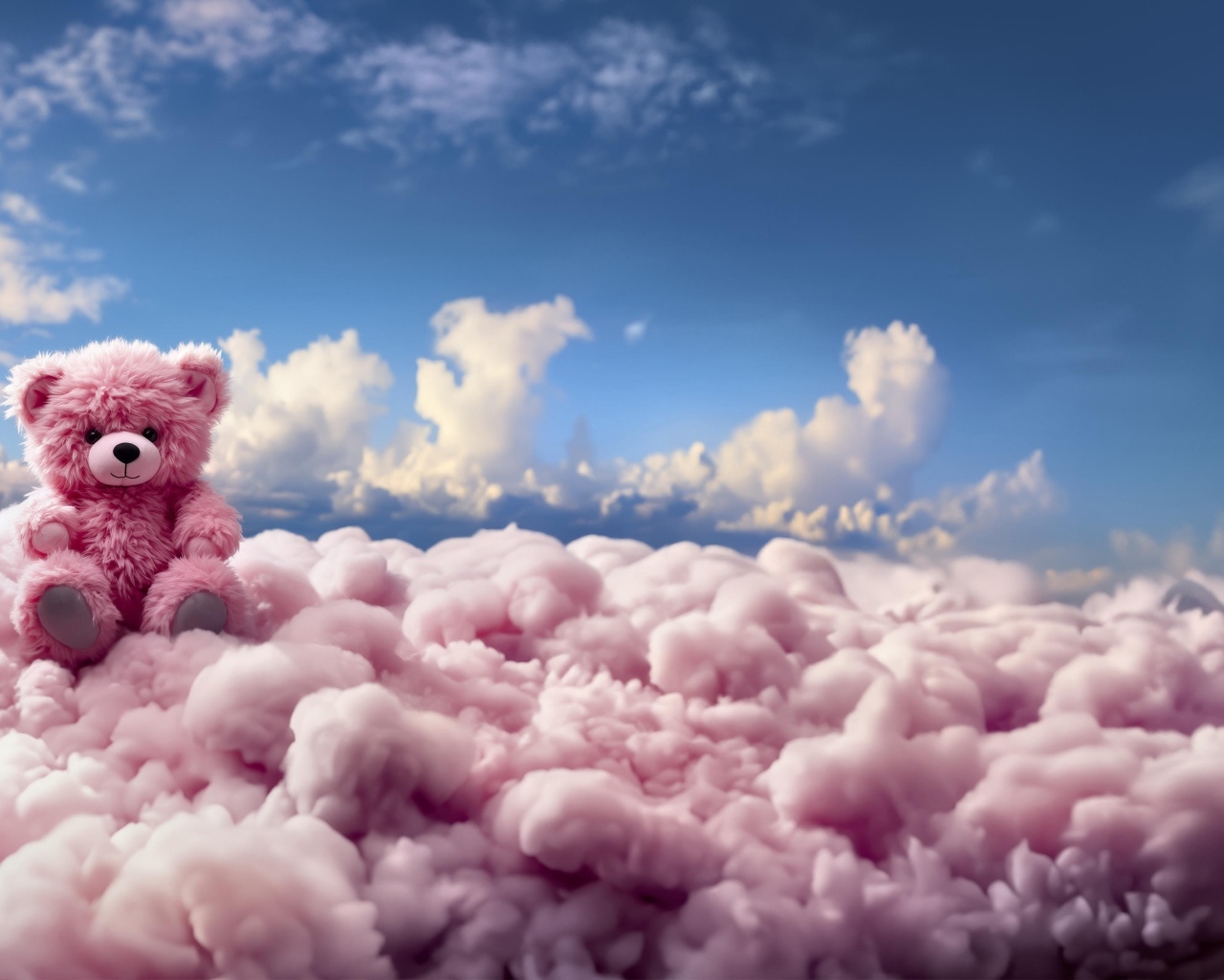 Розовый плюшевый медведь сидит на облаке