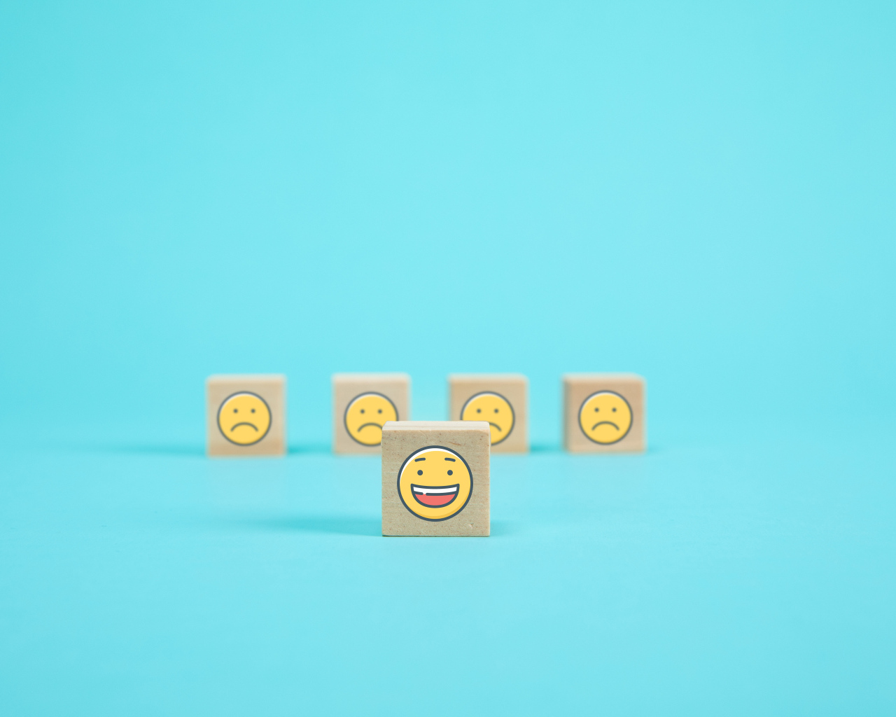 Деревянные кубики со смайлами на голубом фоне