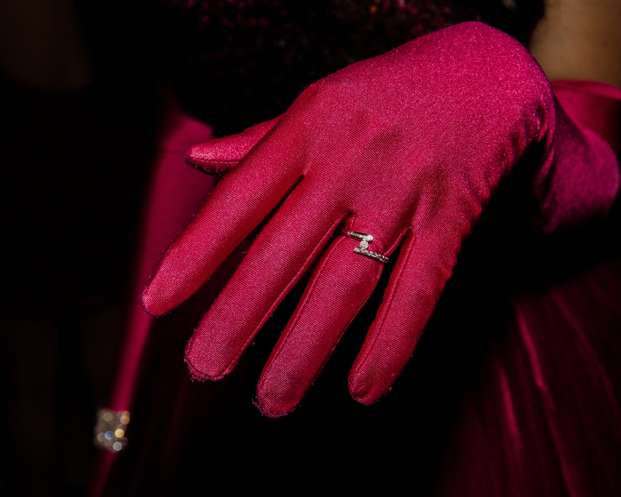 Женская рука с красной перчаткой и кольцом