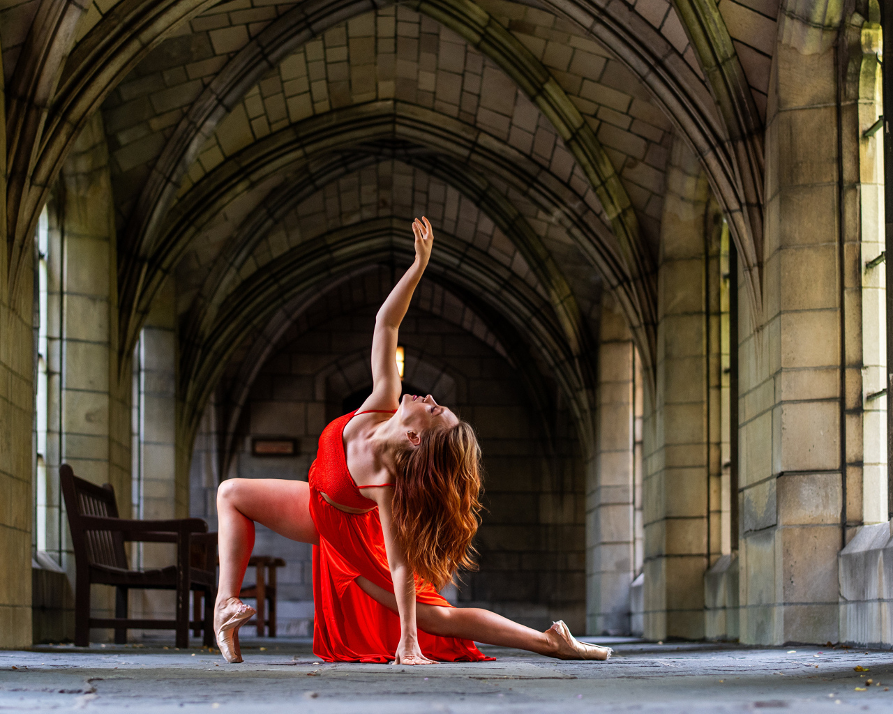 Девушка в красном наряде танцует в здании