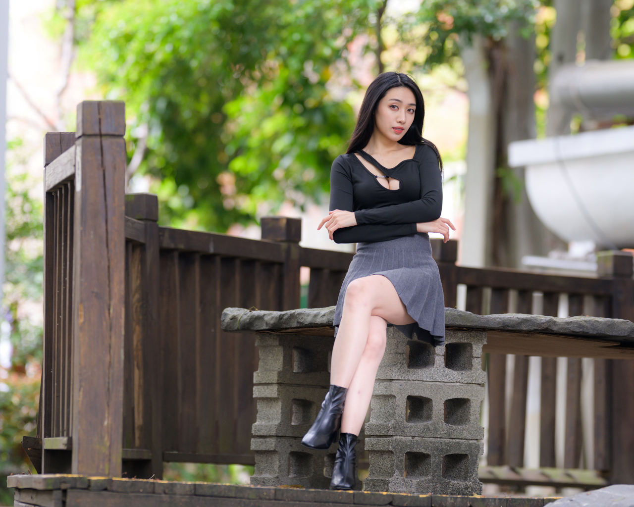 Девушка в короткой юбке сидит на лавке