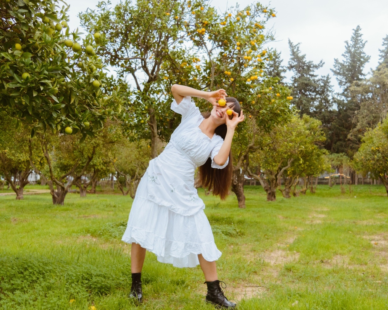 Девушка в белом платье закрыла глаза лимонами