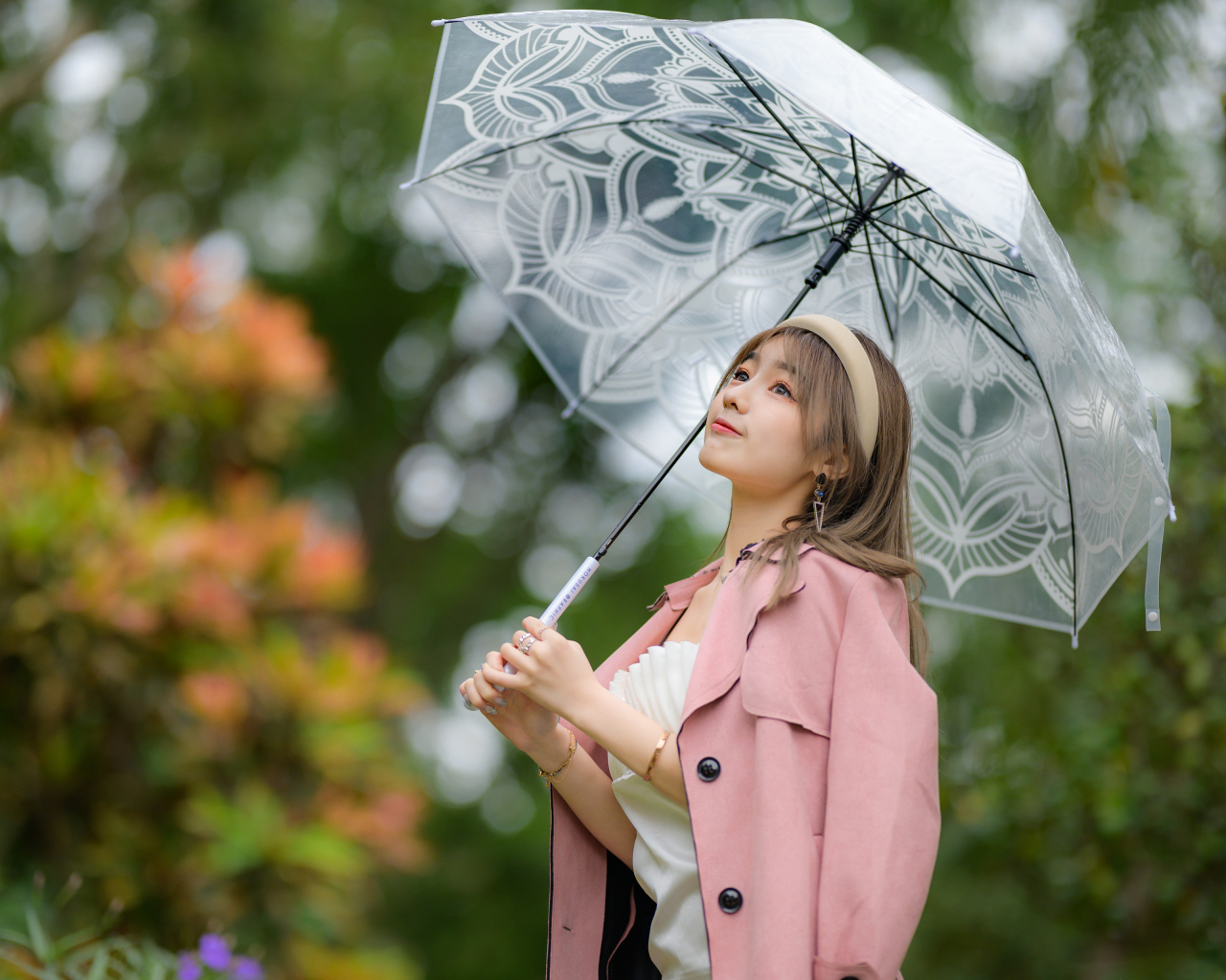 Девушка азиатка в пальто под прозрачным зонтом