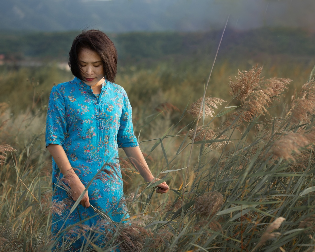 Девушка азиатка в платье на поле с колосьями
