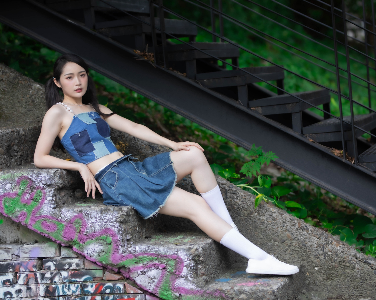 Девушка азиатка в юбке лежит на лестнице