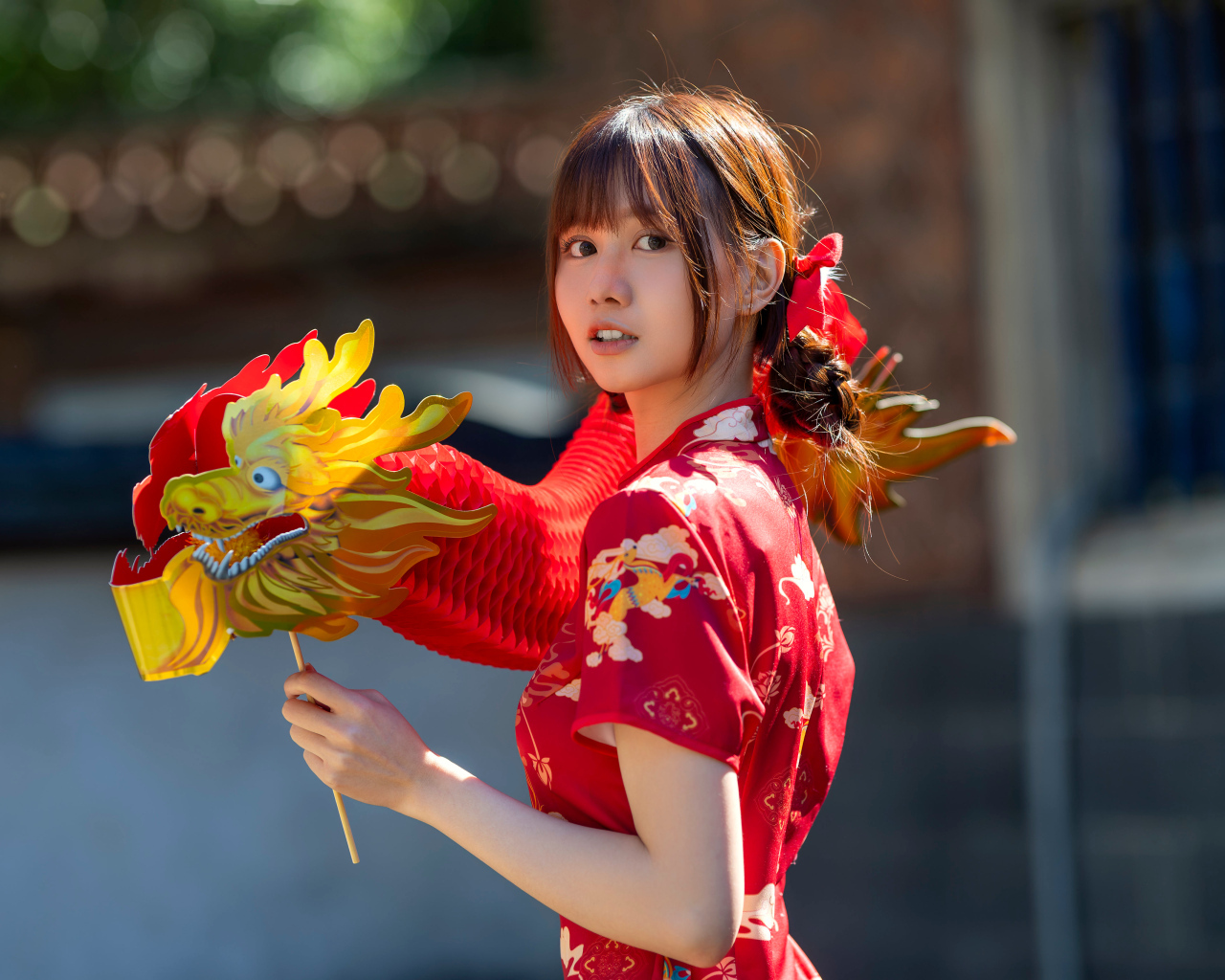 Азиатка в красном платье с бумажным драконом