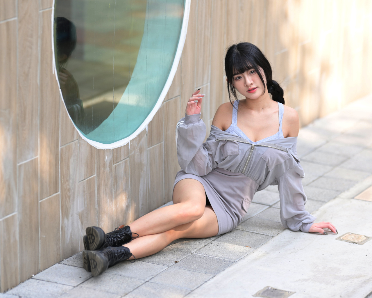 Азиатка лежит на полу у окна