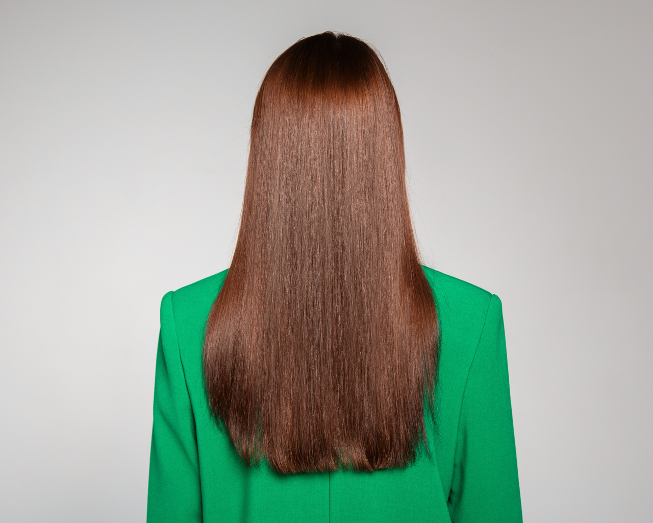 Красивые волосы девушки в зеленом пиджаке