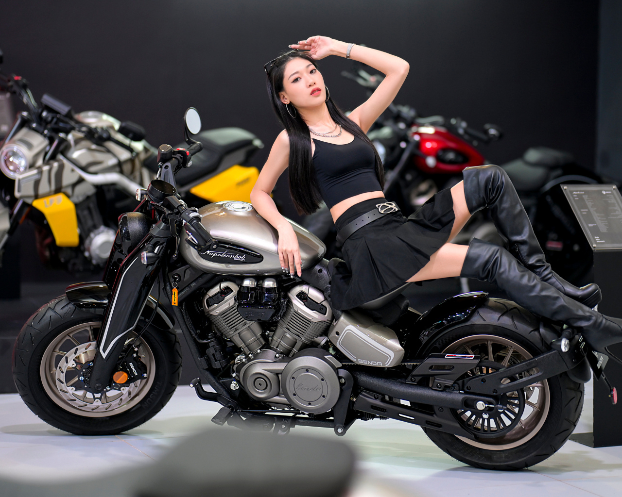 Брюнетка азиатка лежит на мотоцикле