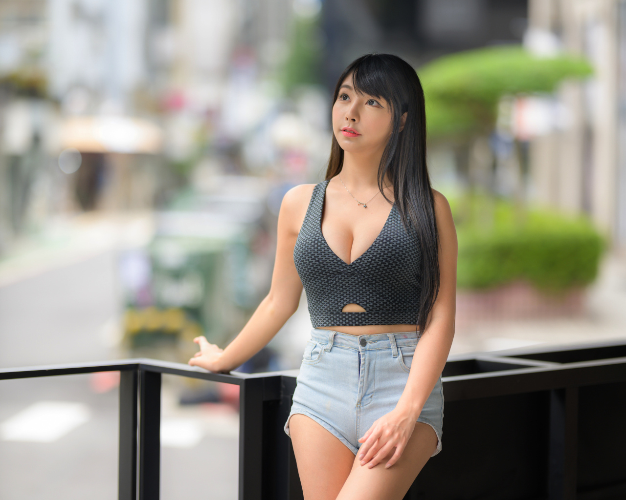 Мечтательная девушка азиатка в коротких шортах