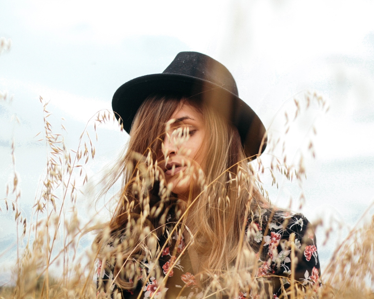 Девушка в черной шляпе в траве