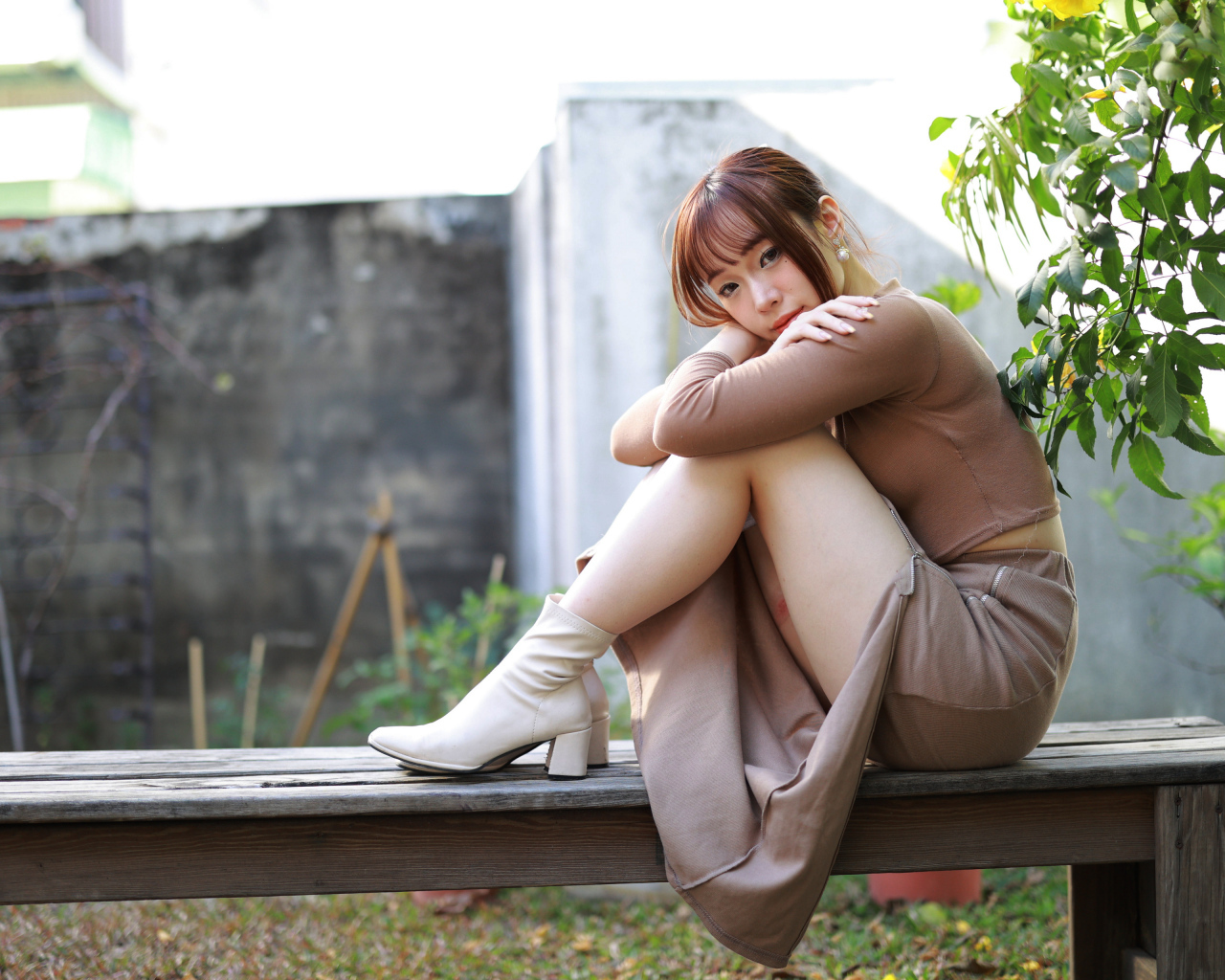 Скромная молодая азиатка сидит на лавке