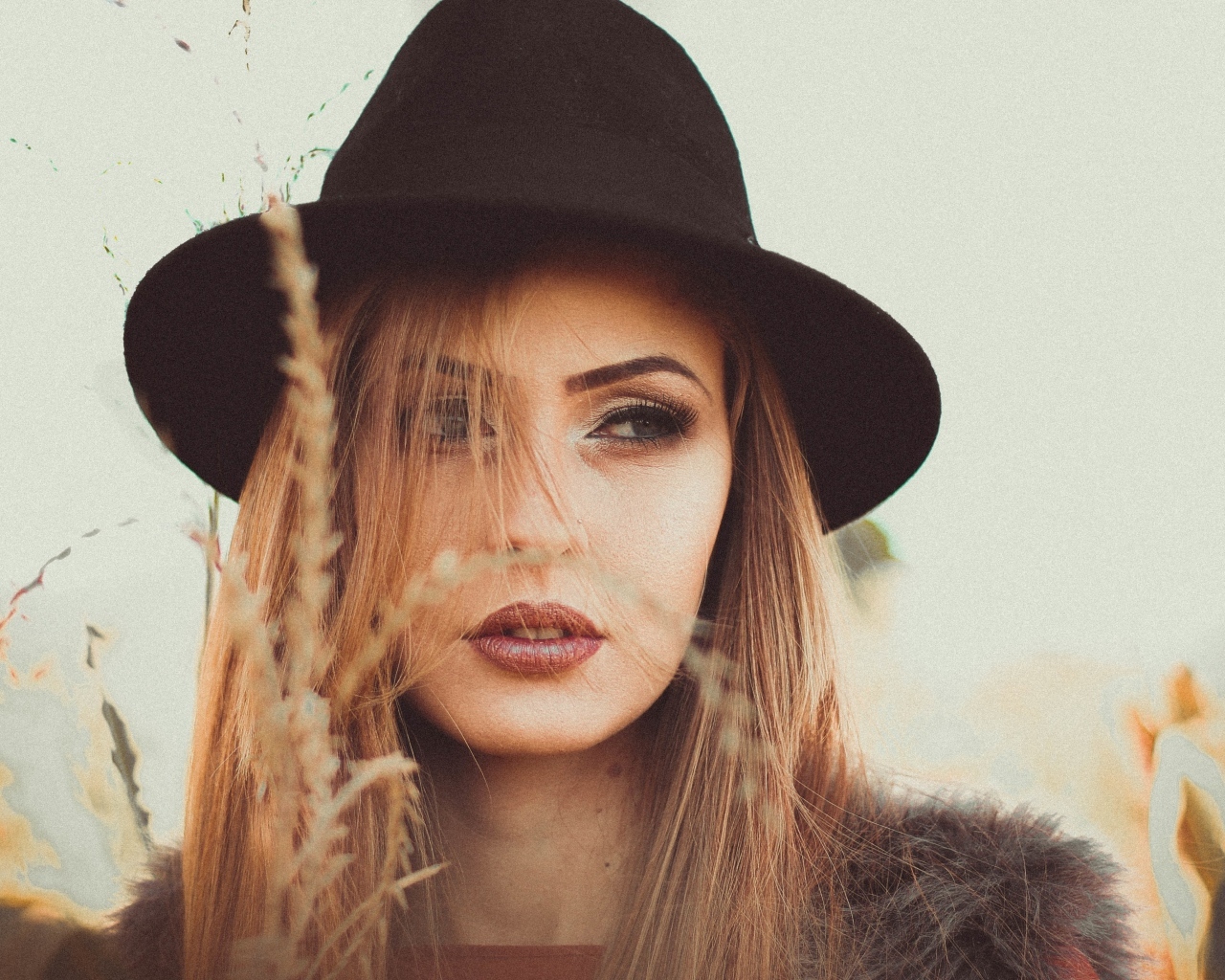 Серьезная девушка в черной шляпе 