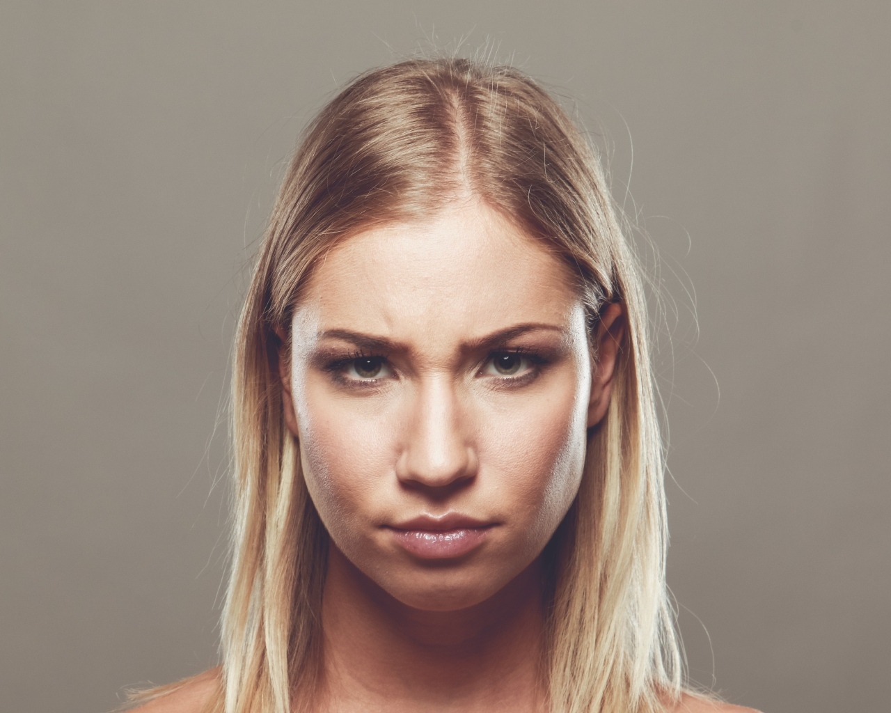 Серьезная девушка с короткой стрижкой на сером фоне