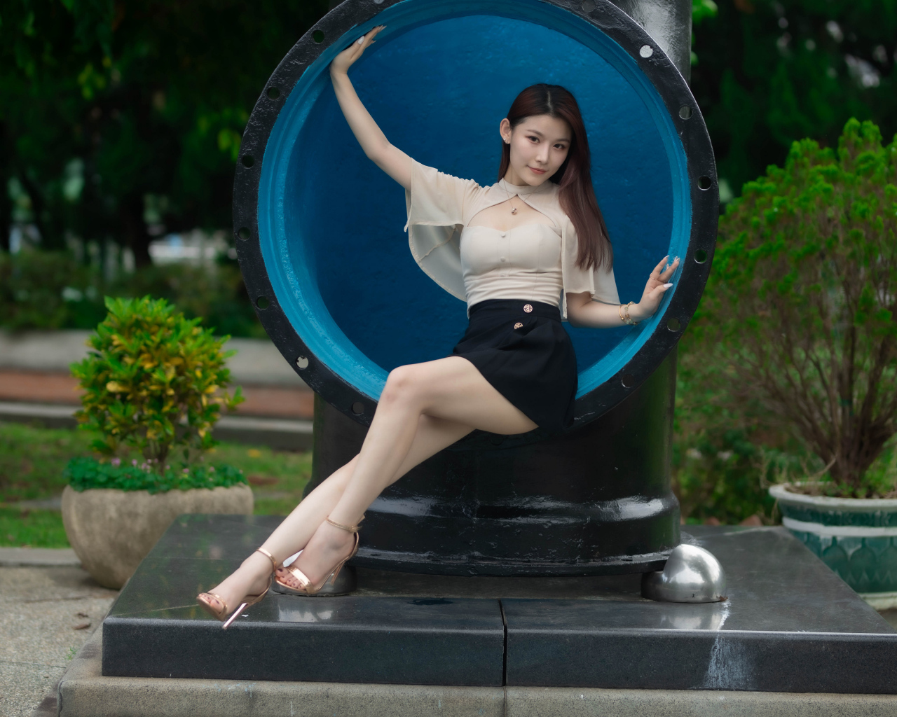 Стройная длинноногая азиатка сидит в трубе