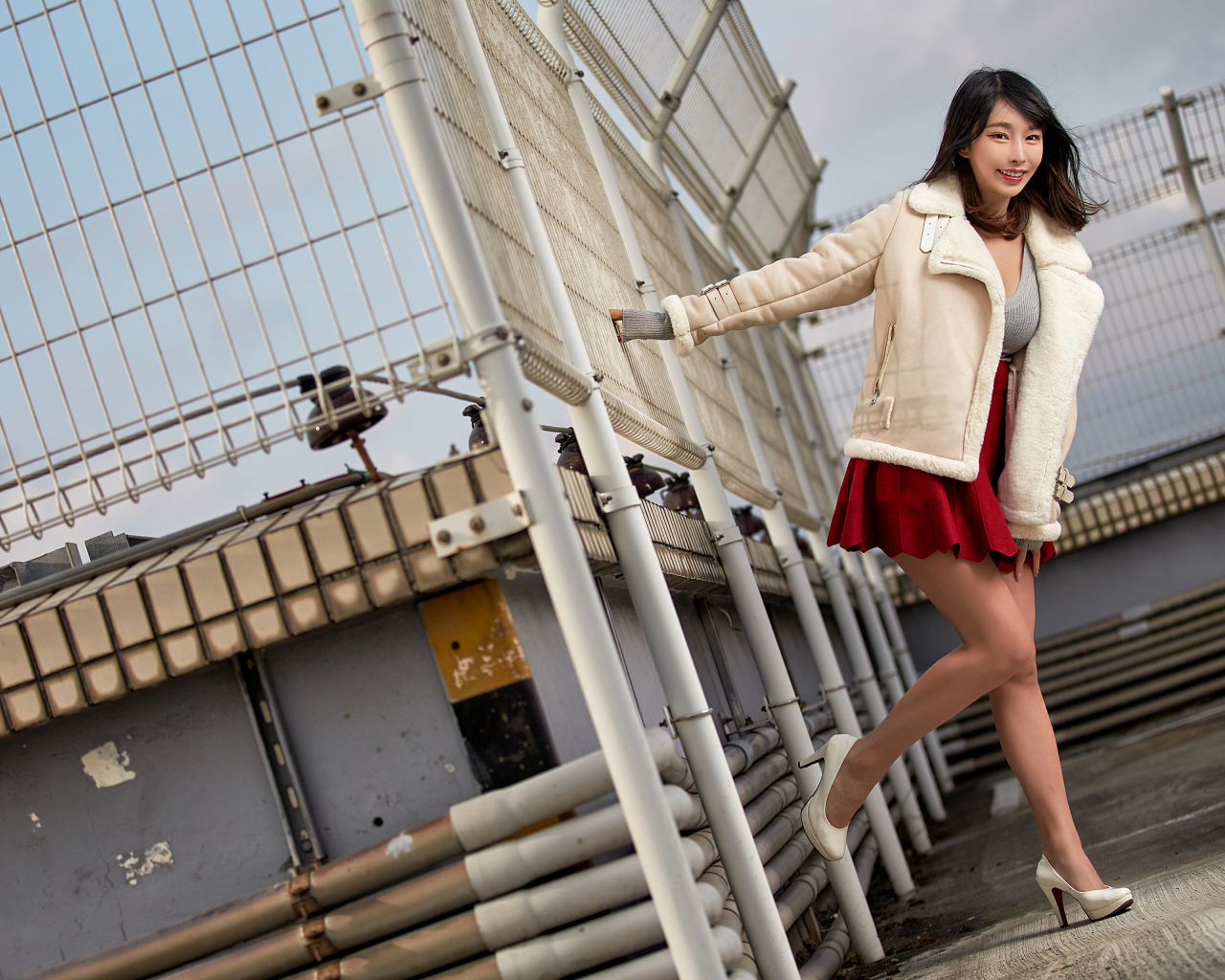 Улыбающаяся девушка азиатка в теплой куртке