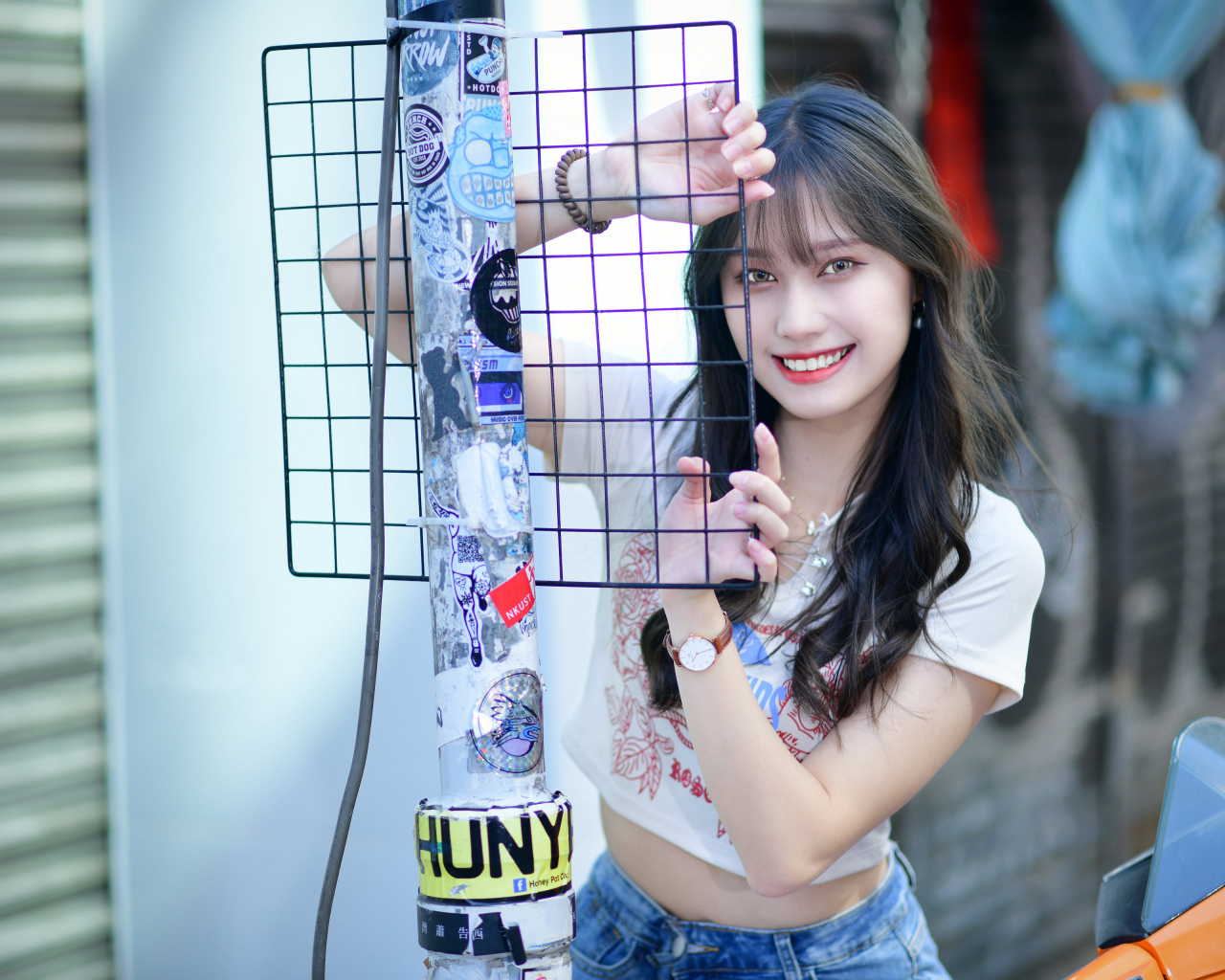 Улыбающаяся азиатка держится за сетку
