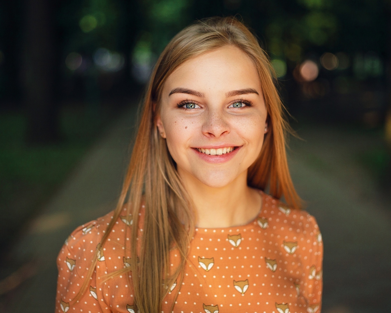 Улыбающаяся милая зеленоглазая девушка