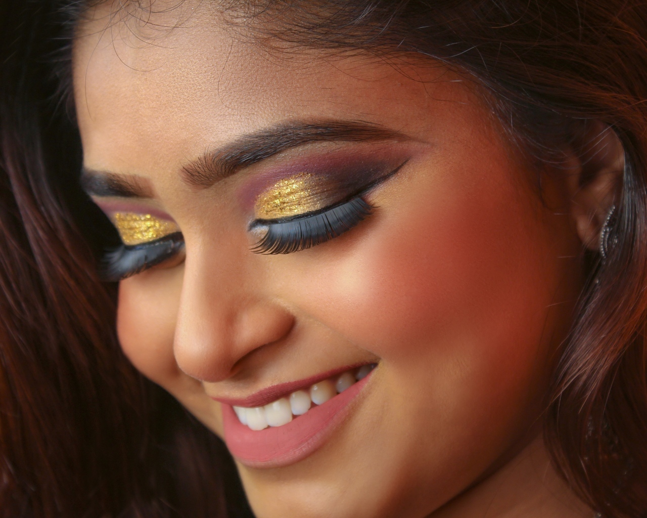 Улыбающаяся девушка с макияжем на глазах