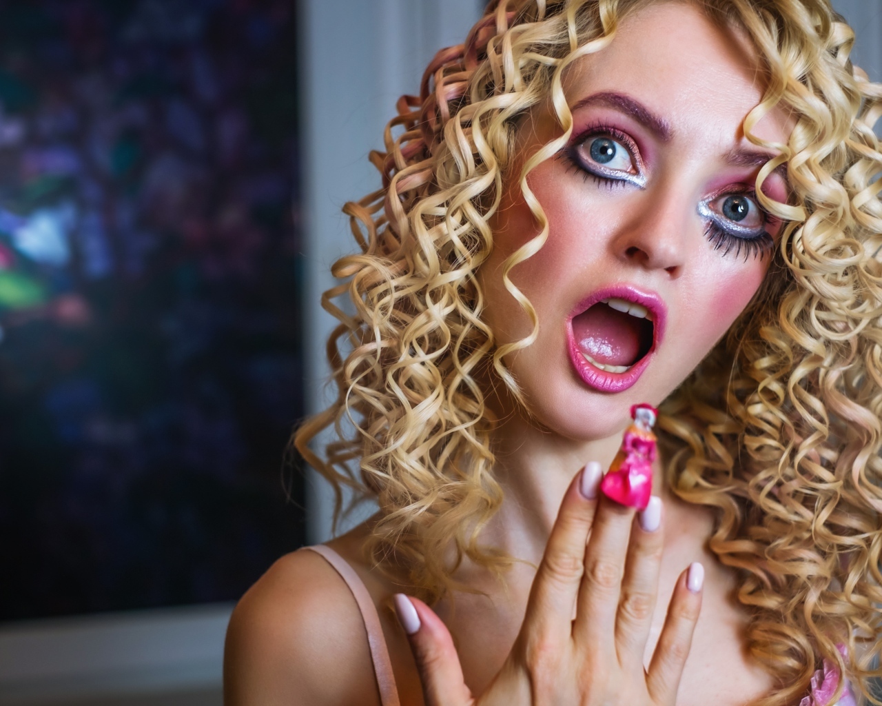 Удивленная девушка блондинка с макияжем куклы