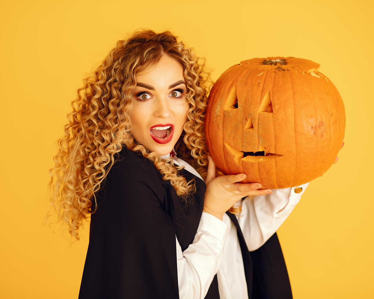 Удивленная девушка с тыквой на Хэллоуин