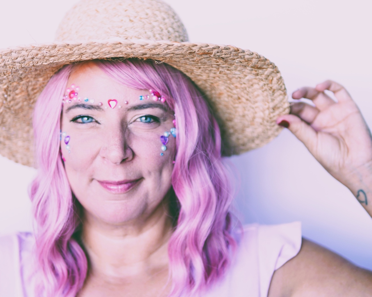 Женщина в шляпе с розовыми волосами