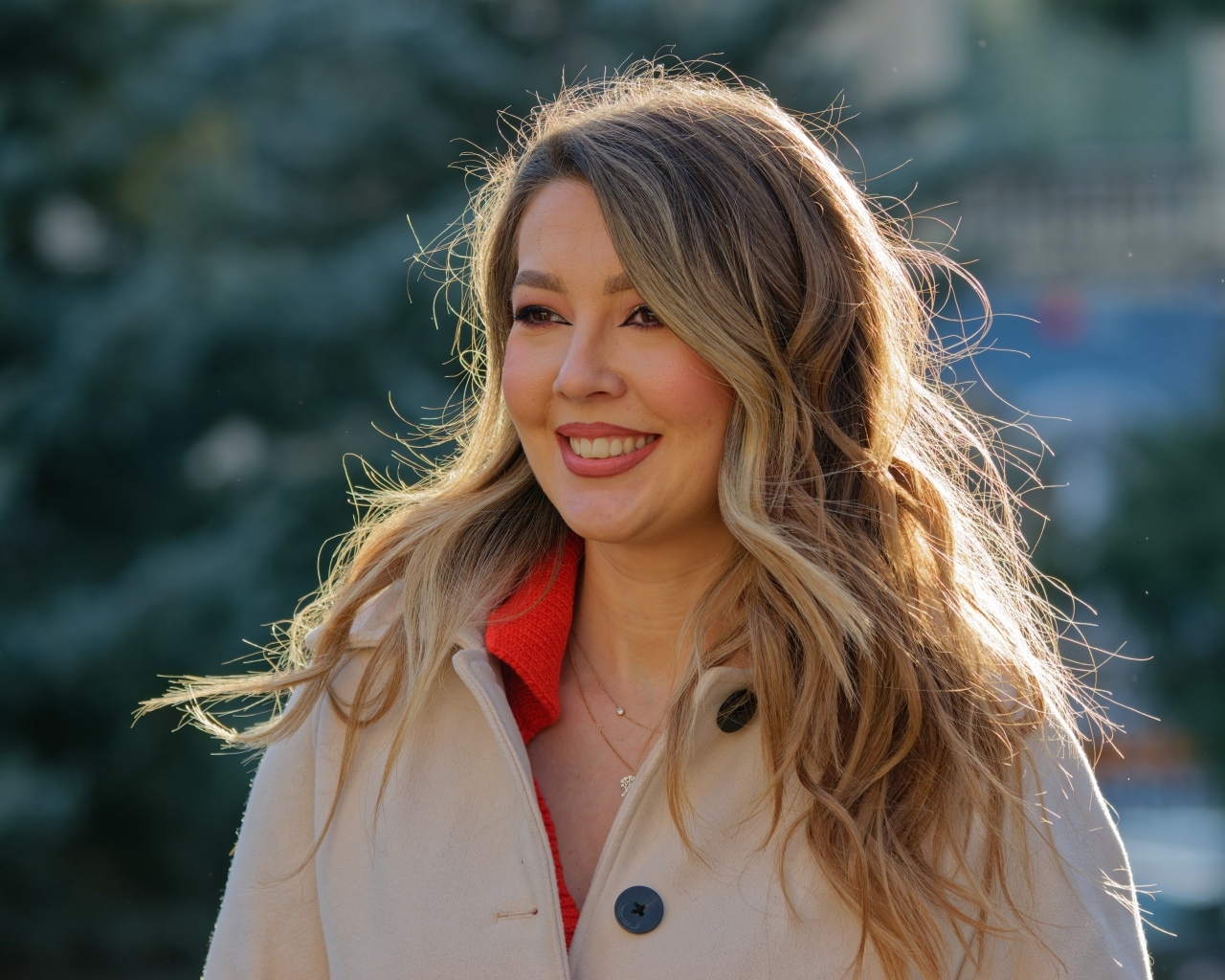 Женщина с милой улыбкой в пальто на улице