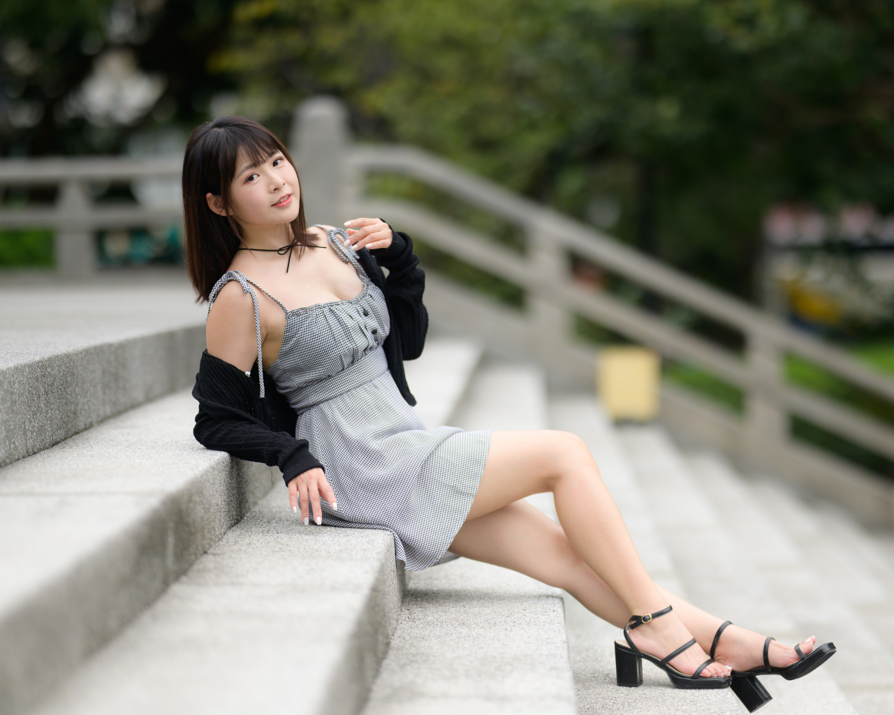 Молодая азиатка в платье лежит на ступеньках