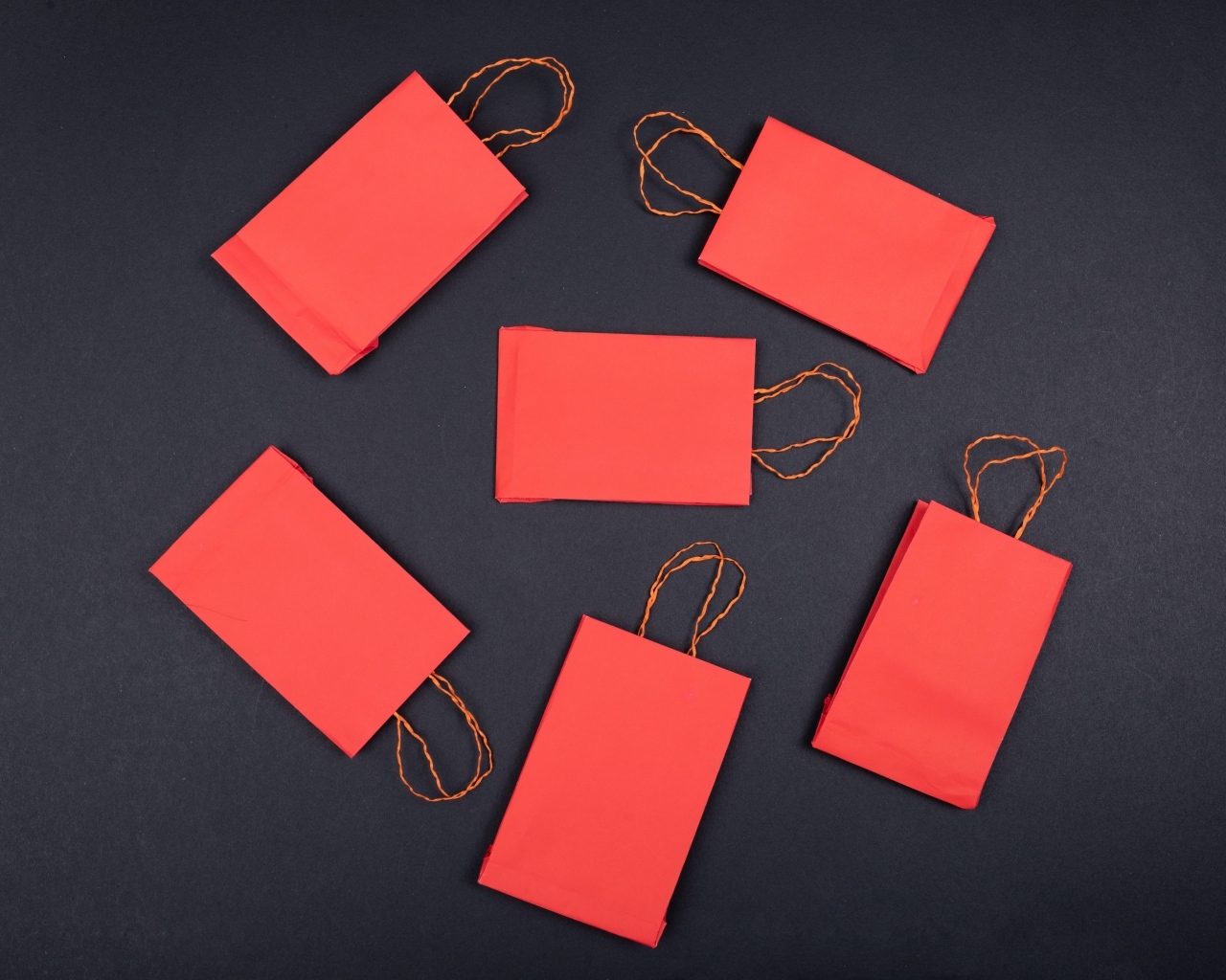 Красные пакетики для подарков на черном столе