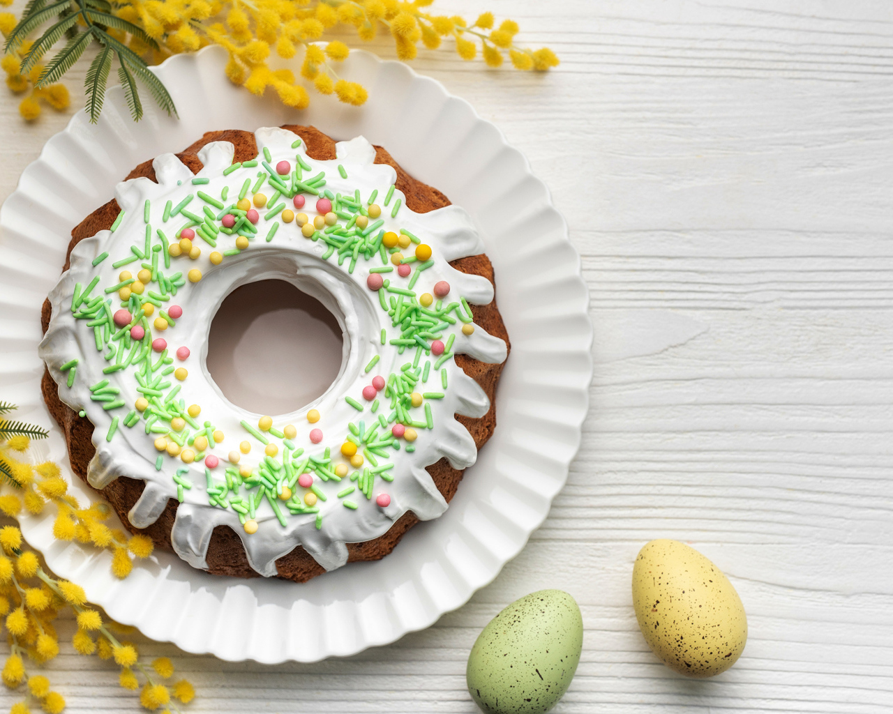 Красивый пасхальный кулич с веткой мимозы и яйцами