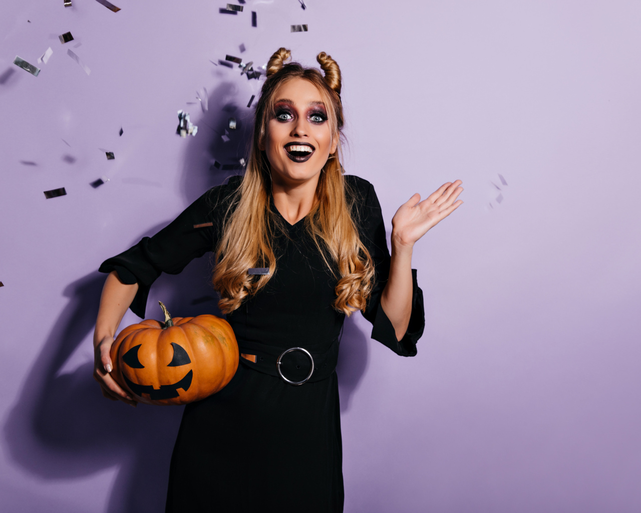 Девушка в черном костюме с тыквой на праздник Хэллоуин
